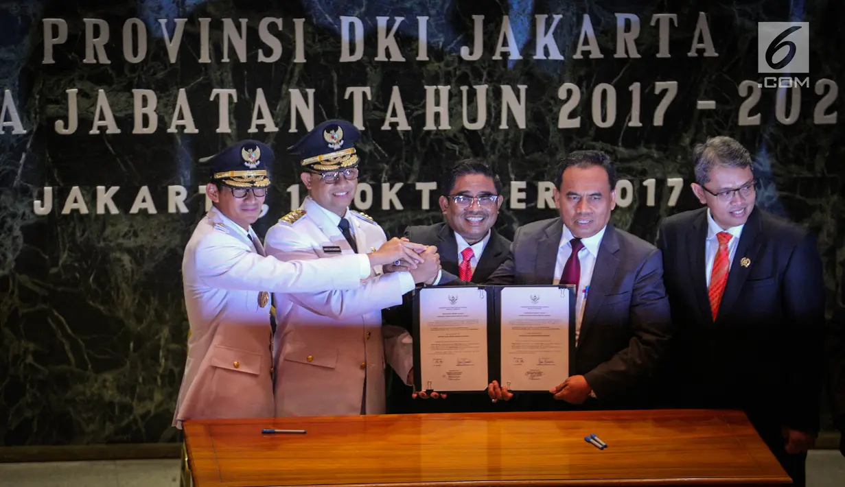 Gubernur dan Wagub DKI Jakarta Anies Baswedan (kedua kiri) dan Sandiaga Uno (kiri) berfoto bersama Dirjen Otonomi Daerah Kemendagri Sumarsono, Sekda DKI Jakarta Saefullah usai sertijab di Balai Kota, Jakarta, Senin (16/10). (Liputan6.com/Faizal Fanani)