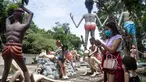 Para pengunjung mengambil foto di depan patung-patung yang menggambarkan nasib orang-orang yang tidak menjunjung tinggi lima ajaran Buddha di sebuah taman yang menggambarkan neraka versi Buddha di kuil Wat Saeng Suk di provinsi pantai Thailand Chonburi (9/7/2020). (AFP/Lillian Suwanrumpha)