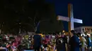 Dan Beazley dan putranya Joey membawa salib besar dalam sebuah peringatan yang didirikan di alun-alun kota untuk menghormati para korban yang tewas dalam penembakan di sekolah dasar awal pekan ini di Uvalde, Texas, Amerika Serikat, 28 Mei 2022. (AP Photo/ Jae C.Hong)