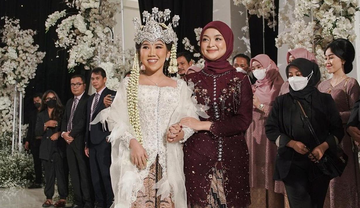 Komika Neneng yang merupakan sahabat dari Kiky Saputri tampak selalu menemani dalam serangkaian pernikahan. Dalam acara pernikahan, perempuan kelahiran Garut, 6 Maret 1998 itu tampil menawan jadi bridesmaid dengan balutan kebaya merah maroon. tidak sedikit warganet yang memuji penampilannya begitu adem bak ubin masjid. (Liputan6.com/IG/@nenengrismawulandari)