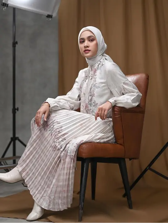 Cut Syifa tampil serba putih yang cocok untuk lebaran. Ia mengenakan atasan kemeja lengan panjang bermotif dipadukan rok panjang plisket bermotif dan kerudung polos. [@cutsyifaa]