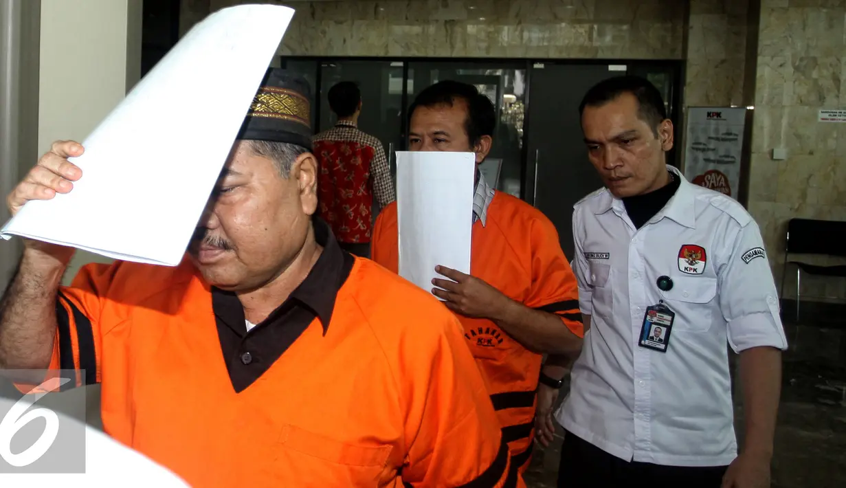 Syamsir Yusfan dan Dermawan Ginting menutup mukanya dengan kertas usai menjalani pemeriksaan di Gedung KPK, Jakarta, Jumat (27/7/2015). Mereka diperiksa terkait sengketa Bantuan Sosial dan Bantuan Daerah Bawahan (BDB) Sumut. (Liputan6.com/Yoppy Renato)
