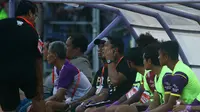 Johan Prasetyo menyampaikan instruksi pelatih Budihardjo Thalib lewat headset ponsel kepada asisten Alfiat saat laga Persik kontra Persis di Stadion Brawijaya, Kota Kediri, Jumat (6/9/2019). (Bola.com/Gatot Susetyo)