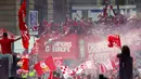 Para pemain Liverpool menyapa fans saat parade juara Liga Champions 2019 di Liverpool, Minggu (2/6). Ribuan fans tumpah ruah di jalanan untuk merayakan keberhasilan pemain membawa pulang trofi Si Kuping Besar ke kota Liverpool. (AP/Richard Sellers)