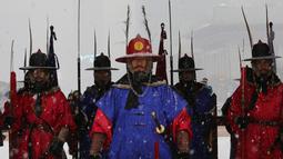Penjaga istana mengenakan seragam militer tradisional berdiri selama hujan salju di Istana Gyeongbok di Seoul, Korea Selatan (13/12). Istana Gyeongbok aslinya didirikan tahun 1394 oleh Jeong do jeon, seorang arsitek.  (AP Photo/Ahn Young-joon)