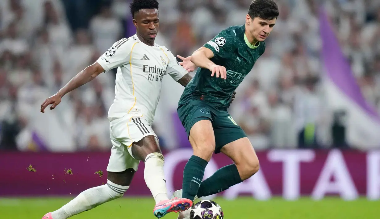 Hingga babak kedua berakhir, skor 3-0 untuk kemenangan Real Madrid bertahan. Tampak dalam foto, pemain Real Madrid, Vinicius Junior (kiri) berebut bola dengan Abdukodir Khusanov dari Manchester City saat pertandingan leg pertama babak 16 besar Liga Champions 2025/2026 di stadion Santiago Bernabeu, Rabu 11 Maret 2026 waktu setempat atau Kamis 12 Maret 2026 dini hari WIB. (AP Photo/Jose Breton)