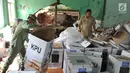 Petugas kecamatan menyelamatkan kotak suara kardus yang sebagian rusak terendam banjir di gudang tempat penyimpanan logistik di Kecamatan Ciseeng, Bogor, Senin (15/4). Lebih dari 600 kotak suara rusak akibat tembok gudang jebol diterpa hujan lebat dan angin kencang semalam. (merdeka.com/Arie Basuki)