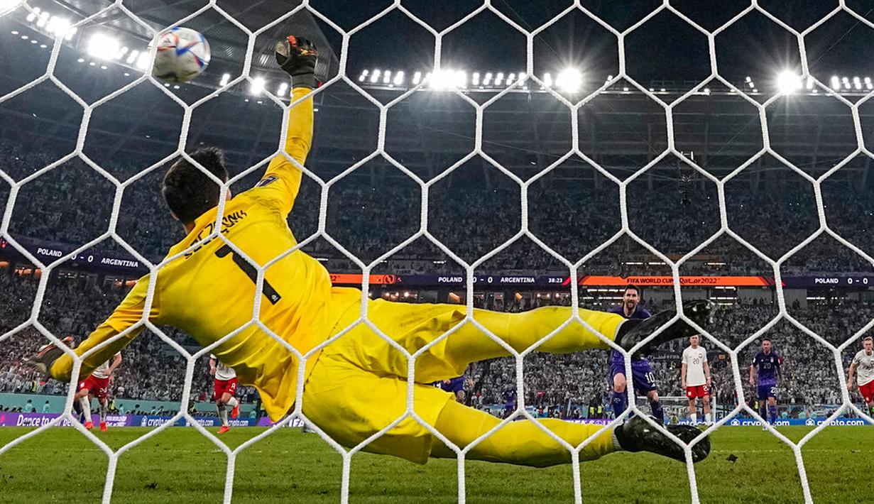 Penjaga gawang Polandia Wojciech Szczesny menyelamatkan tendangan penalti pemain Argentina Lionel Messi pada pertandingan sepak bola Grup C Piala Dunia 2022 di Stadion 974, Doha, Qatar, 30 November 2022. Argentina lolos ke babak 16 besar Piala Dunia 2022 dengan status juara Grup C usai mengalahkan Polandia 2-0. (AP Photo/Ariel Schalit)