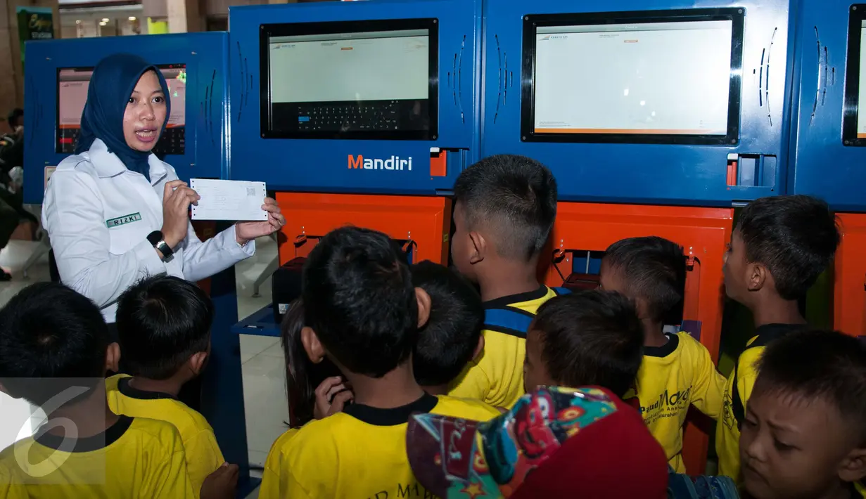 Petugas KAI menunjukan cara memesan tiket kepada murid PAUD di Stasiun Gambir, Jakarta, Senin (20/3). PT KAI mengajak anak Indonesia untuk mengenal lebih jauh tentang kereta api sekaligus memperingati hari dongeng sedunia. (Liputan6.com/Gempur M Surya)