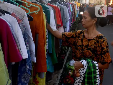 Warga memilih pakaian bekas saat kegiatan Ramadhan Berbagi: Bazaar Sayuran dan Baju Layak Pakai di Jalan Jati Padang, Pasar Minggu, Jakarta Selatan, Jumat (7/4/2023). (merdeka.com/Arie Basuki)