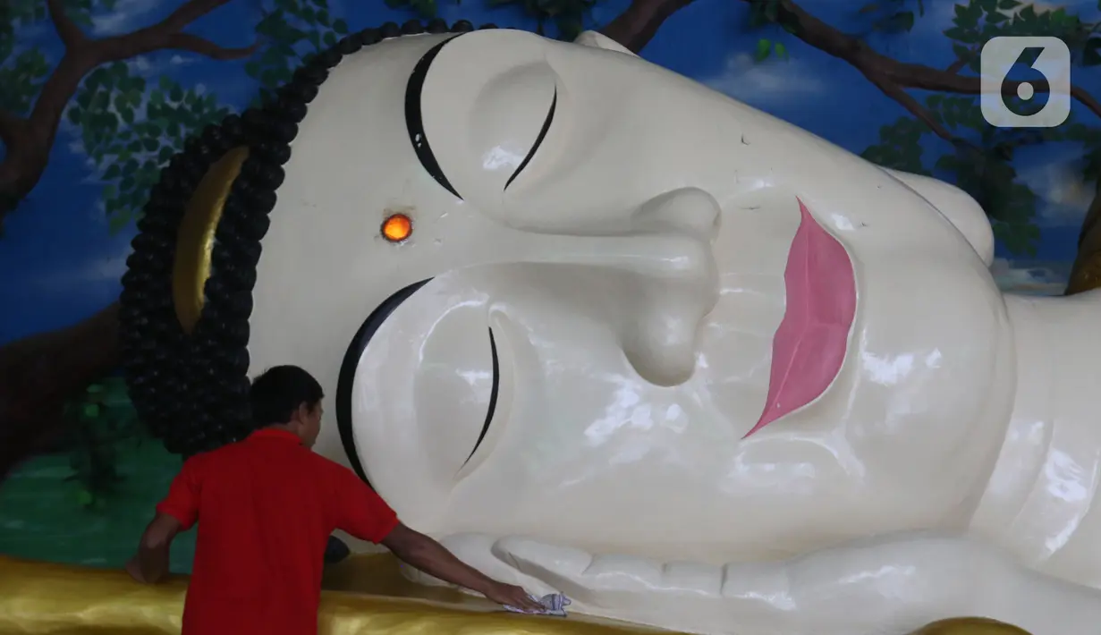 Pekerja membersihkan patung Buddha Tidur di Vihara Buddha Dharma dan 8 Pho Sat, Desa Tonjong, Tajurhalang, Bogor, Selasa (25/5/2021). Vihara itu mulai dihias dan dibersihkan untuk memberi kenyamanan bagi umat Budha yang akan beribadah saat peringatan Hari Raya Waisak. (Liputan6.com/Herman Zakharia)