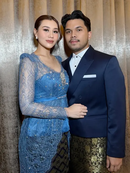 Kebaya dengan model kerah v neck ini memiliki inner tube korset warna senada dengan aksen belt kain dihiasi beads. Melengkapinya dengan bros silver disematkan di bagian dada serta mengenakan bawahan kain songket warna motif gold. [@ochiipramita]