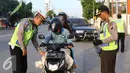 Petugas Kepolisian memberhentikan pengendara motor di Simpang Maya, Tegal, Jawa Tengah Minggu (10/7). Pemberhentian dilakukan untuk mengecek barang bawaan agar tidak membahayakan pengendara lain. (Liputan6.com/Herman Zakharia)