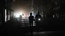 Sebelumnya, pada Senin 16 Maret 2026, Cuba’s Electric Union (UNE) melaporkan bahwa sistem listrik di negara tersebut mengalami keruntuhan total. Tampak dalam foto, orang-orang berjalan di jalanan tanpa aliran listrik selama pemadaman listrik nasional di Havana, Kuba pada Sabtu 21 Maret 2026. (Yamil LAGE/AFP)