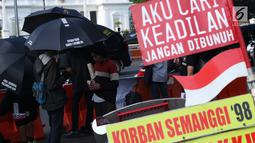Peserta aksi Kamisan saat aksi di kawasan Silang Monas depan Istana Negara, Jakarta, Kamis (7/2). Seiring aksi Kamisan, JSKK meminta komitmen pemerintah untuk menyelesaikan kasus pelanggaran HAM masa lalu. (Liputan6.com/Helmi Fithriansyah)