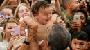 Presiden AS Barack Obama saat menggendong bayi yang menangis selama kunjungannya di Stasiun Udara Korps Marinir Iwakuni, Jepang (27/5). Kedatangan Obama ke Jepang untuk mennghadiri pertemuan G7. (REUTERS/Carlos Barria)