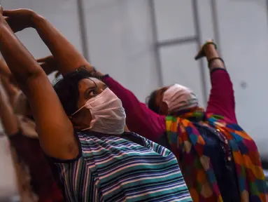Pasien melakukan yoga di dalam bangsal di kompleks olahraga Commonwealth Games (CWG) Village yang sementara diubah menjadi pusat perawatan Covid-19 di New Delhi, India, Kamis (16/7/2020). Kasus virus corona (Covid-19) di India hampir menyentuh angka 1 juta orang.  (Money SHARMA / AFP)