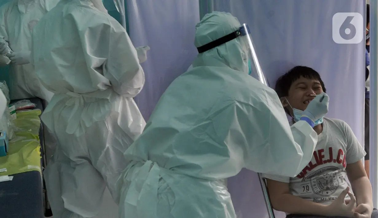 Paramedis melakukan swab test PCR kepada seorang anak di Puskesmas Kramat Jati, Jakarta Timur, Rabu (13/1/2020). Setiap harinya, Puskesmas Kramat Jati menyediakan kuota 300 swab test PCR  secara gratis untuk memutus mata rantai penyebaran COVID-19. (merdeka.com/Arie Basuki)