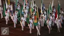 Anggota Paskibra membawa bendera kontingen saat defile peserta PON XIX Jabar di Stadion Gelora Bandung Lautan Api, Bandung, Sabtu (17/9). 9.533 atlet akan berlaga di 44 cabang olahraga. (Liputan6.com/Helmi Fithriansyah)