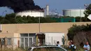 Sejumlah petugas berjaga di dekat kilang minyak milik perusahaan Amerika di Etang de Berre, Marseille, Perancis, (14/7/2015). kebakaran yang terjadi merupakan kebakaran terbesar kelima di Perancis. (REUTERS/Philippe Laurenson)