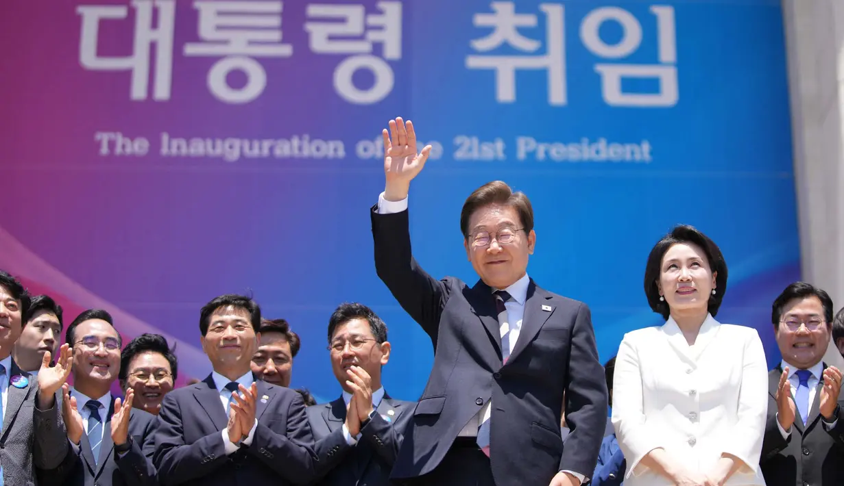 Presiden Korea Selatan Lee Jae-myung (mengangkat tangan) bersama istrinya Kim Hye-kyung saat bersiap untuk meninggalkan tempat setelah upacara pelantikan di Majelis Nasional di Seoul pada 4 Juni 2025. (Lee Jin-man/POOL/AFP)