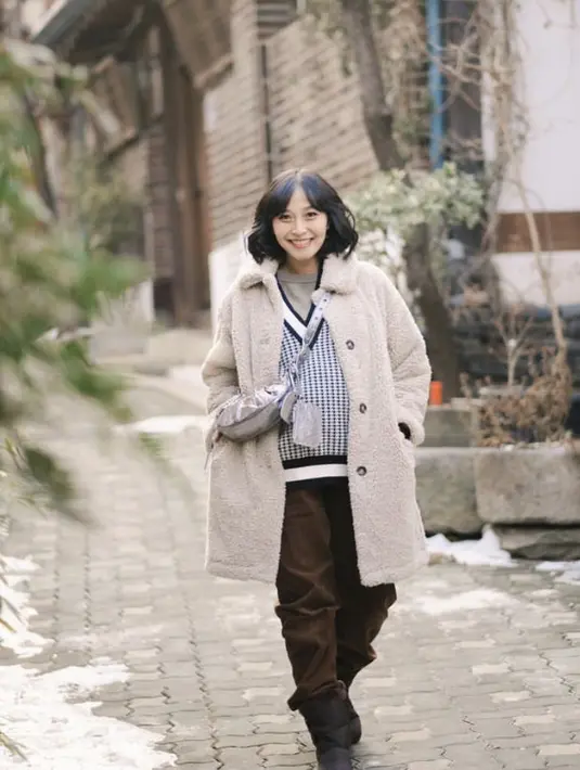 <p>Berlibur di Korea, Rinni Wulandari tampil dengan gaya layering mulai dari vest hingga coat berbulu, dipadukan celana bahannya.&nbsp;(@rinni_w)</p>