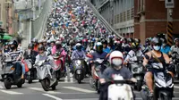 Pengendara sepeda motor melintasi Jembatan Taipei pada jam sibuk pagi hari, China (21/5). Sebelumnya telah beredar sebuah video mengejutkan mengenai kondisi sebuah jalan yang dipenuhi oleh antrean motor. (AFP Photo/Chris Stowers)