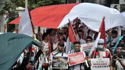 Dalam aksinya, massa menggelar upacara pengibaran bendera Indonesia dan Palestina sebagai simbol solidaritas antarkedua negara. (merdeka.com/Iqbal S. Nugroho)