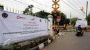 Pengendara motor melintas diantara spanduk sosialisasi penutupan perlintasan KRL Commuter Line sebidang di Pasar Minggu, Jakarta, Selasa (9/5). Penutupan secara permanen akan dilakukan pada 2 Juni mendatang. (Liputan6.com/Helmi Fithriansyah)