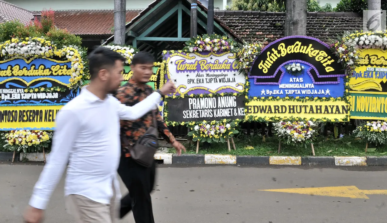 Pelayat melintasi karangan bunga duka cita untuk mendiang Eka Tjipta Widjaja di depan Rumah Duka Sentosa RSPAD Gatot Soebroto, Jakarta, Minggu (27/1). Pendiri Sinar Mas Group tersebut meninggal dunia pada 26 Januari 2019. (Merdeka.com/Iqbal Nugroho)