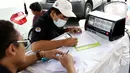 Petugas sudin lingkungan hidup mengisi form uji emisi gas buang kendaraan di kawasan Senayan, Jakarta, Rabu (18/7). Uji emisi gratis dilakukan untuk menekan tingkat pencemaran udara akibat gas buang kendaraan. (Liputan6.com/Immanuel Antonius)