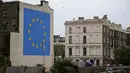 Mural pria tengah menghancurkan salah satu dari 12 bintang kuning bendera Uni Eropa di dinding kawasan Dover, Inggris, Senin (8/5). Bintang kuning itu merupakan simbol kesatuan, solidaritas dan harmoni di antara warga Eropa. (DANIEL LEAL-OLIVAS/AFP)