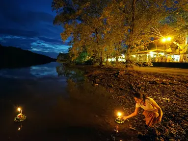 Seorang wanita bersiap menghanyutkan lentera air dalam Festival Loy Krathong di Bandar Seri Begawan, Brunei (31/10/2020).  Festival Loy Krathong, sebuah perayaan tradisional Thailand, tahun ini jatuh pada Sabtu (31/10). (Xinhua/Jeffrey Wong)