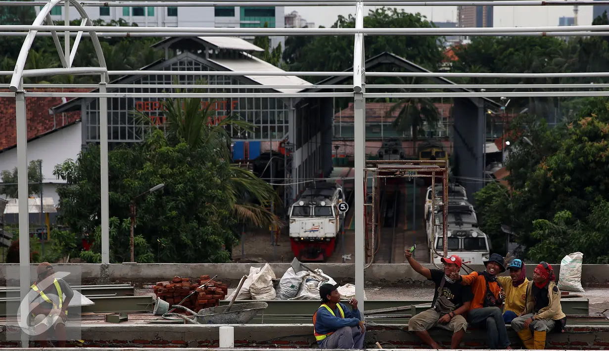 Sejumlah pekerja pembangunan JPO di Stasiun Tanah Abang tampak beristirahat, Jakarta, Senin (17/10). JPO ini ditargetkan kelar paling lambat Januari 2017. (Liputan6.com/Johan Tallo)