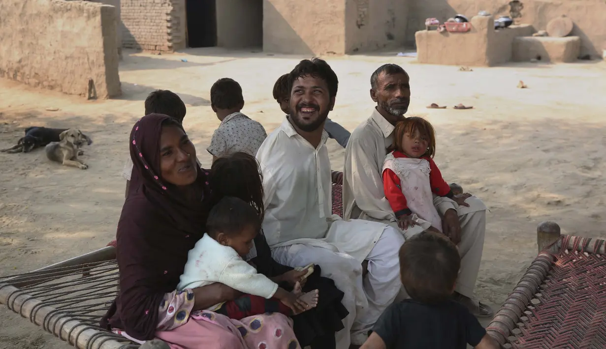 Mohammad Ikram, yang bermain snooker dengan dagunya, duduk bersama anggota keluarganya di rumah mereka di sebuah desa dekat kota Samundri, Pakistan, Minggu (25/10/2020). (AP Photo/Anjum Naveed)