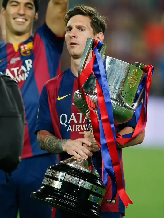 Penyerang Barcelona, Lionel Messi membawa trofi Copa del Rey usai memenangkan final piala Raja di Nou Camp, Spanyol (31/5/2015). Barcelona berhasil menaklukkan Bilbao dengan skor akhir 3-1. (Reuters/Albert Gea)