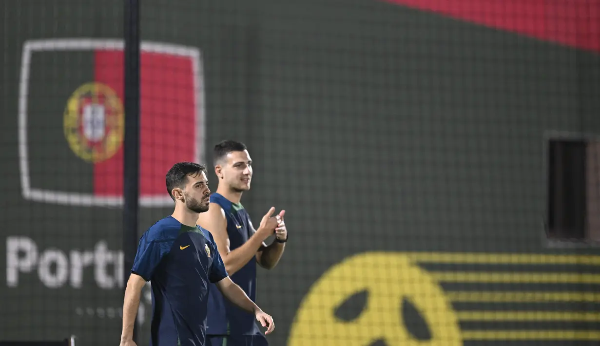 Gelandang Portugal, Bernardo Silva (Kiri) dan bek Diogo Dalot menghadiri sesi latihan di tempat latihan Al Shahaniya SC, barat laut Doha pada 5 Desember 2022. Portugal lolos ke babak 16 besar Piala Dunia 2022 sebagai juara Grup H meski di laga terakhir kalah dari Korea Selatan. (AFP/Patricia De Melo Moreira)