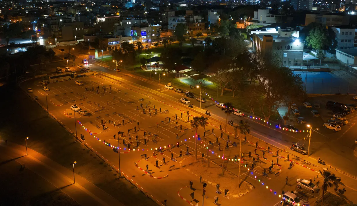 Suasana saat umat muslim melaksanakan salat tarawih di sebuah tempat parkir di kota campuran Yahudi-Arab, Jaffa, Israel, Minggu (10/5/2020). Israel menutup tempat umum dan rumah ibadah untuk mencegah penyebaran virus corona COVID-19. (AP Photo/Oded Balilty)