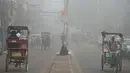 Seorang tunawisma India duduk di jalanan kota New Delhi yang diselimuti kabut asap, Rabu (8/11). Kabut asap tebal akibat polusi udara yang parah menyebabkan aktivitas di pusat kota New Delhi lumpuh seketika. (SAJJAD HUSSAIN/AFP)