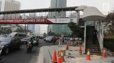 Pengendara melintas melintas di bawah jembatan penyeberangan orang (JPO) di Bundaran HI, Jakarta, Selasa (24/7). Pemprov DKI berencana merobohkan JPO tersebut karena menghalangi pandangan ke Patung Selamat Datang. (Liputan6.com/Arya Manggala)