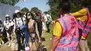 Seorang wanita disemprot air oleh petugas pada hari pertama Festival Glastonbury di Worthy Farm di Somerset, Inggris, Rabu (22/6/2022). Lebih dari 200.000 penggemar musik dan megabintang Paul McCartney, Billie Eilish, dan Kendrick Lamar turun ke pedesaan Inggris minggu ini saat Festival Glastonbury kembali setelah festival jeda tiga tahun. (Yui Mok/PA via AP)