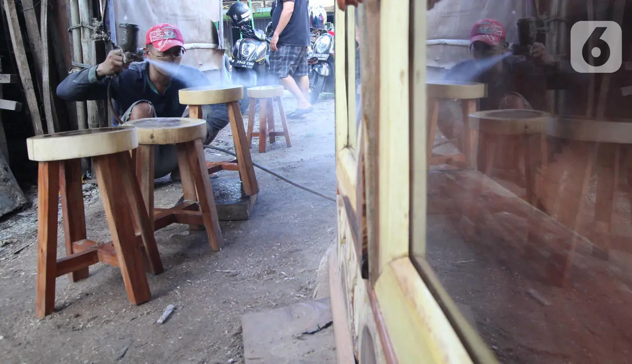 Perajin menyelesaikan pembuatan kursi dari kayu bekas di Pinang, Kota Tangerang, Banten, Minggu (28/3/2021). Furnitur berbahan dasar kayu bekas tersebut dijual dari harga Rp50.000 hingga lima juta rupiah dan dipasarkan hingga ke Sumatera dan Kalimantan. (Liputan6.com/Angga Yuniar)