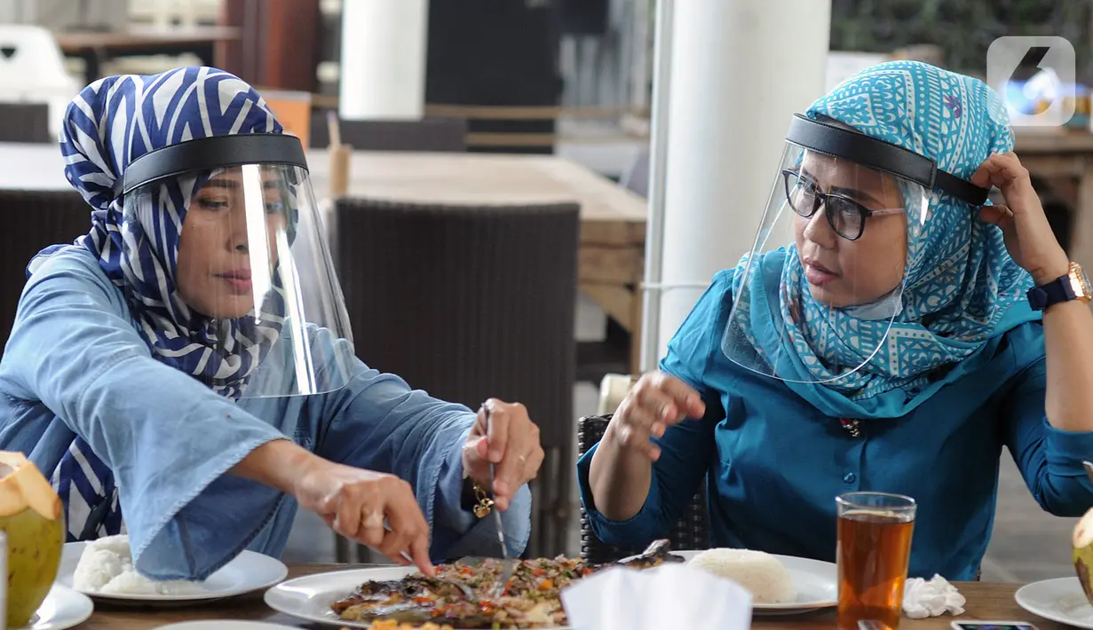 Pengunjung mengenakan pelindung wajah saat makan di Restoran Bandar Djakarta, Alam Sutra, Tangerang Selatan, Banten, Rabu (10/6/2020). Tangerang dan Tangerang Selatan menjalankan PSBB transisi menuju kenormalan baru dengan menerapkan protokol kesehatan COVID-19. (merdeka.com/Arie Basuki)