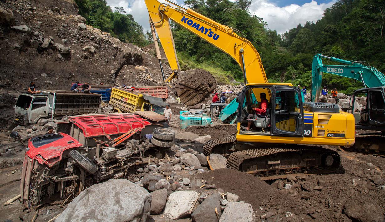 Beberapa alat berat dikerahkan untuk mengevakuasi puluhan truk yang terkubur di pasir setelah longsor lumpur akibat hujan dari Gunung Merapi di Sungai Senowo, Magelang, Jawa Tengah pada Rabu 4 Maret 2026. Banjir lahar dingin dari Gunung Merapi menerjang Sungai Senowo di Kabupaten Magelang, Jawa Tengah. (Devi Rahman/AFP)