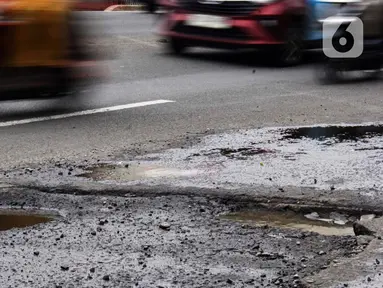 Sejumlah pengendara kendaraan bermotor melewati salah satu titik kerusakan di Jalan Raya Parung-Ciputat Kota Depok, Jawa Barat, Senin (10/2/2025). (Magang/Liputan6.com/Muhammad Rizal)