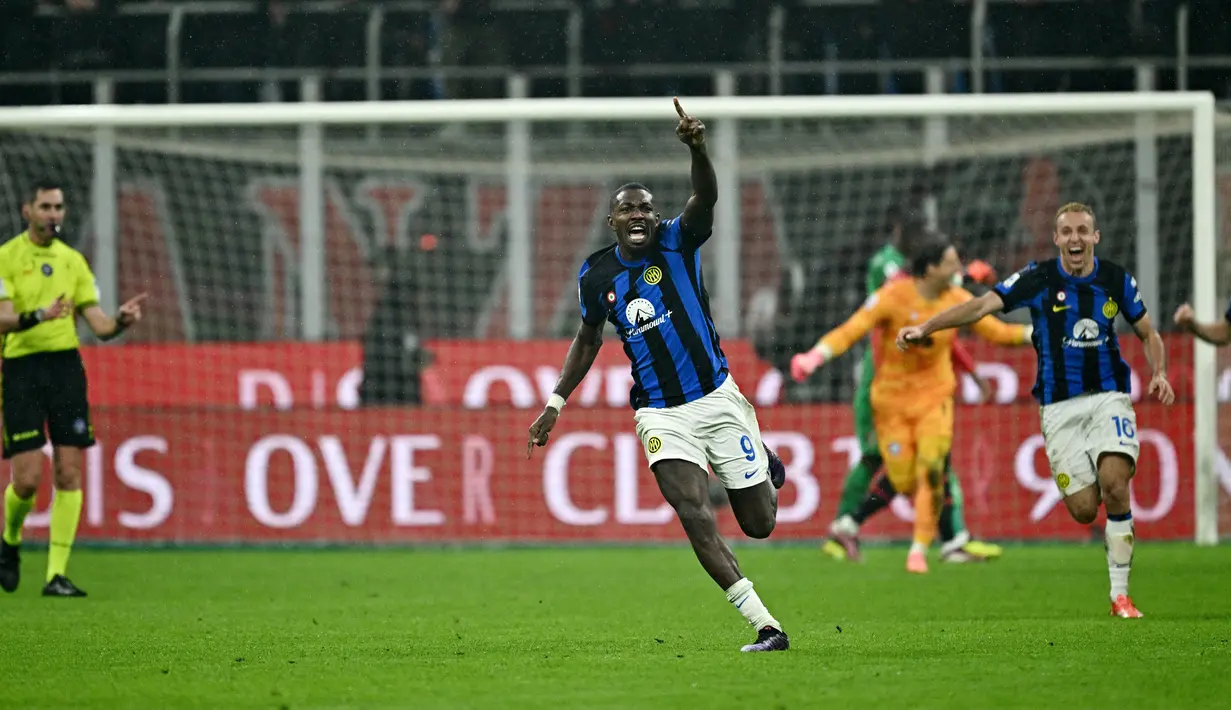 Pemain Inter Milan, Marcus Thuram, melakukan selebrasi saat perayaan juara setelah menaklukkan AC Milan dalam duel pekan ke-33 Serie A 2023/2024 di Stadion San Siro, Selasa (23/4/2024). Inter menang dengan skor 2-1. (AFP/Gabriel Bouys)