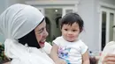 Di kesempatan lainnya, Geni Faruk terlihat menggendong Ameena dalam balutan outfit putih dan manset hijab hitam. Mana gaya favoritmu dari ketiga mama ini saat momong cucu, Sahabat FIMELA? [Foto: Instagram/genifaruk]