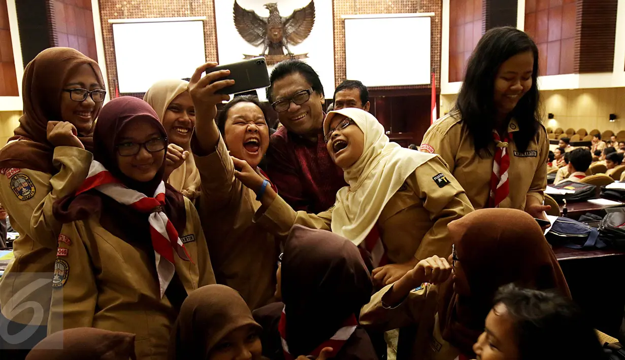 Wakil Ketua MPR Oesman Sapta berselfie dengan sejumlah siswa seusai acara Sosialisasi Empat Pilar di Kompleks Parlemen, Jakarta, Rabu (30/9/2015). Acara sosialisasi empat pilar ini diikuti oleh siswa dari SMA 285 Jakarta. (Liputan6.com/Johan Tallo)