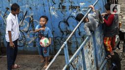 Sejumlah anak masuk ke dalam bak truk untuk bermain sepak bola, kawasan Cengkareng, Jakarta, Rabu (23/2/2022). Minimnya lahan bermain di kawasan tersebut membuat anak-anak memanfaatkan tempat yang bukan semestinya untuk bermain bola. (Liputan6.com/Johan Tallo)