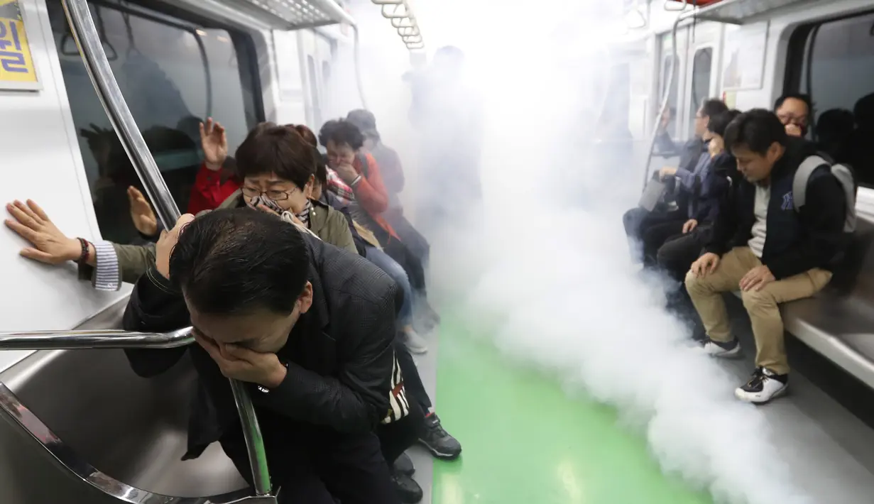 Orang-orang diserang oleh gas tiruan selama latihan anti-terorisme di kereta bawah tanah di stasiun kereta bawah tanah Shindorim di Seoul, Korea Selatan, Selasa 29/10/2019). Latihan anti-terorisme bulan ini dikombinasikan dengan latihan pencegahan bencana. (AP Photo/Ahn Young-joon)